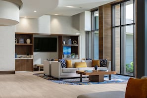 Una sala de estar moderna con sofá, mesa de centro y mueble de entretenimiento.