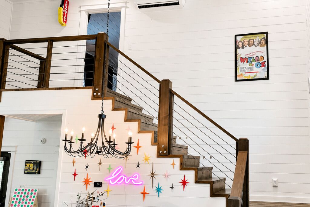 A staircase with a wooden handrail and a chandelier.
