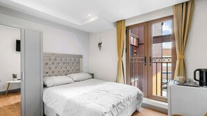 A bedroom with a bed, a desk, a chair, a window with curtains, and a balcony. - Stylish Ensuite Double Room Near Ilford Station (Ilford)