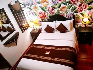 A neatly made bed with a white and brown bedspread, two brown pillows, and a decorative headboard. - Casona Dorada Hotel (Cusco)