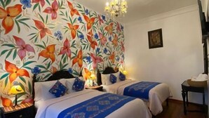 A room with two beds, a chandelier, and a floral wallpaper. - Casona Dorada Hotel (Cusco)