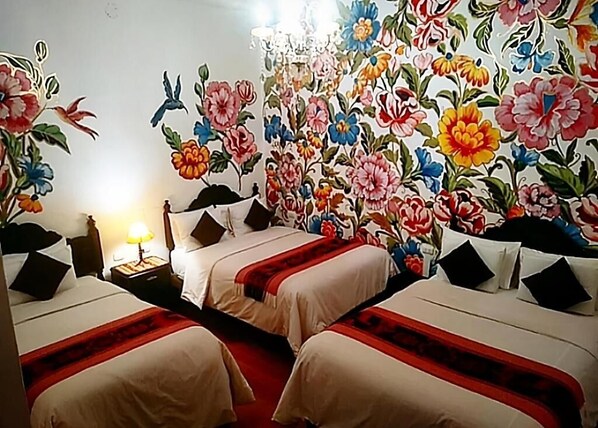 A hotel room with two beds, a nightstand with a lamp, and a floral wallpaper. - Casona Dorada Hotel (Cusco)