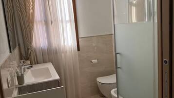 Regadera, secadora de cabello, bidet, toallas