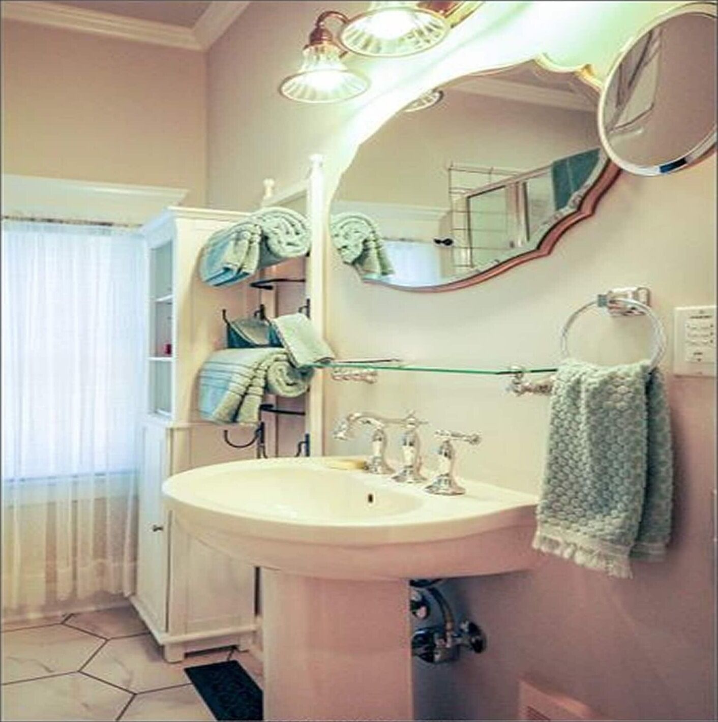A bathroom with a sink, mirror, and towel rack.