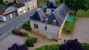 A two-story stone house with a steep roof, a small front porch, and a paved driveway. - Manoir de Cénac 19th century - with swimming pool and large park (Cénac-et-Saint-Julien)