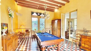 A pool room with a pool table, chairs, a cabinet, and a chandelier. - Manoir de Cénac 19th century - with swimming pool and large park (Cénac-et-Saint-Julien)