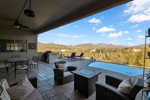 An outdoor patio with a pool, seating, and a view of mountains. - Casa De Kokopelli - Luxurious Desert Retreat with Hot Tub, Infinity Pool, Spe... (Cave Creek)