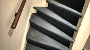 A staircase with dark carpeted steps and a wooden handrail. - Vermeer - luxury authentic room at Museumplein (Amsterdam)