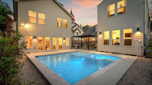 Ein Wohnhaus mit Schwimmbad, überdachter Terrasse und sichtbarer Küche.
