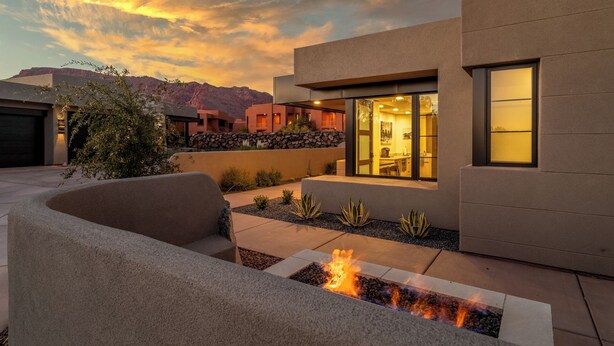 A modern house with a fire feature in the garden, a garage, and a view of mountains. - Beautiful Home Near Snow Canyon, Tuacahn, and Black Desert Resort (Ivins)