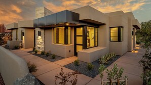 A modern house with a flat roof, large windows, and a stone facade. - Beautiful Home Near Snow Canyon, Tuacahn, and Black Desert Resort (Ivins)