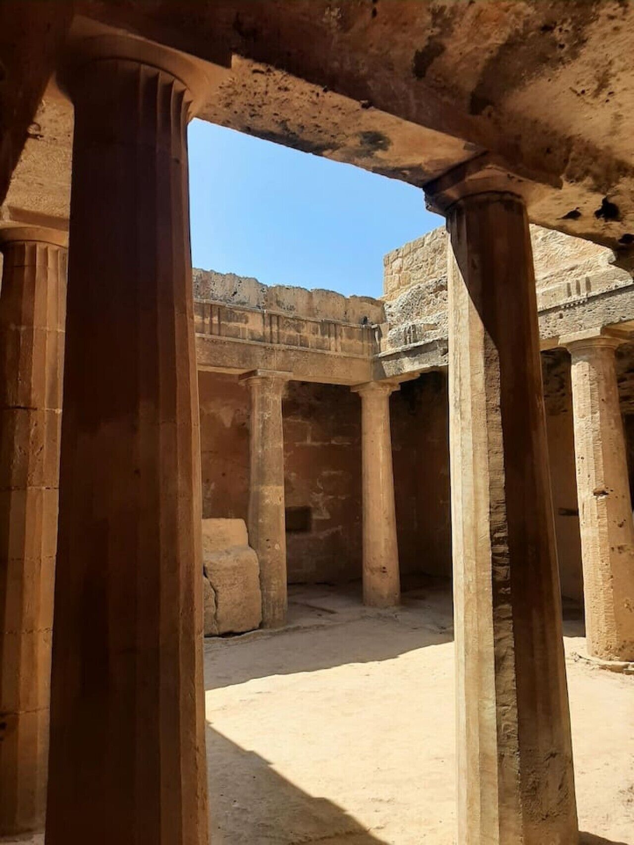 Une structure ancienne en pierre, dotée de colonnes et d’arcs.