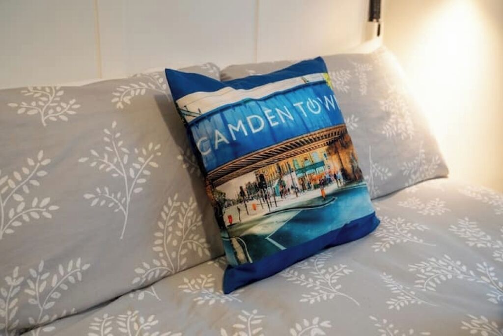 Un oreiller orné d’un motif imprimé, posé sur un lit recouvert d’une couvre-lit à motifs.