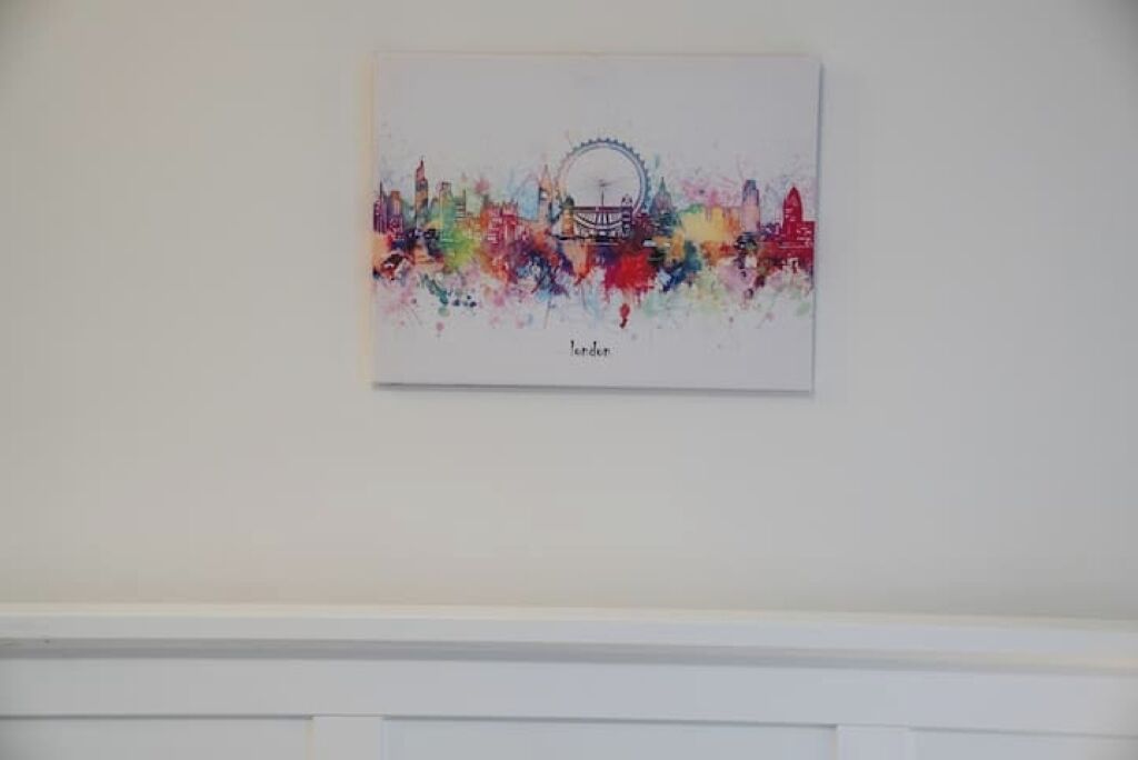 A colorful cityscape artwork on a wall.