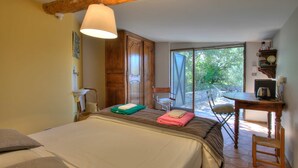 A bedroom with a bed, a chair, a table, and a window. - Proven al Bergerie With Pool Sleeps 4 Gordes (Gordes)