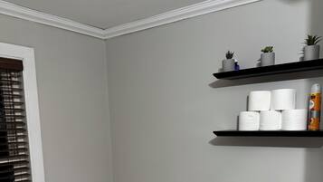 Een douche, handdoeken, zeep, toiletpapier