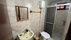 A bathroom with a sink, toilet, and shower area. - Pousada Estação Ferrugem (Garopaba)