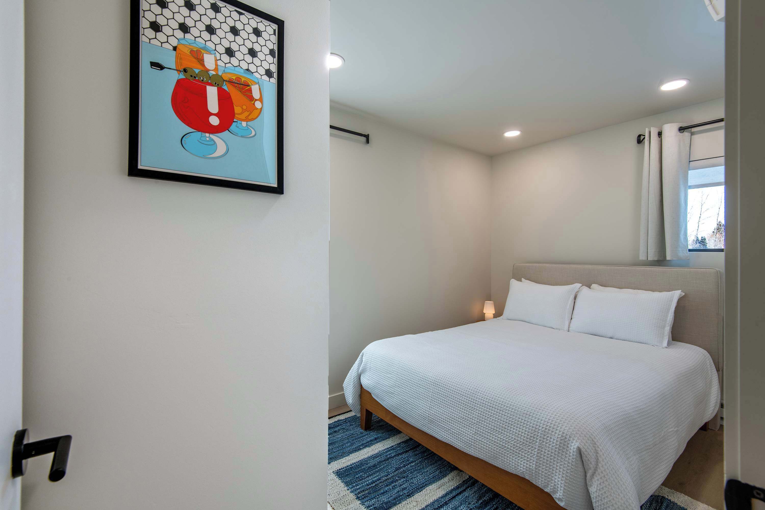 Guest bedroom with queen bed and natural light.