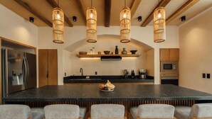 A modern kitchen with a large island, wooden chairs, and pendant lighting. - Luxe Villa 10p, Grill, 2 Private Pools w/Concierge (Tulum)