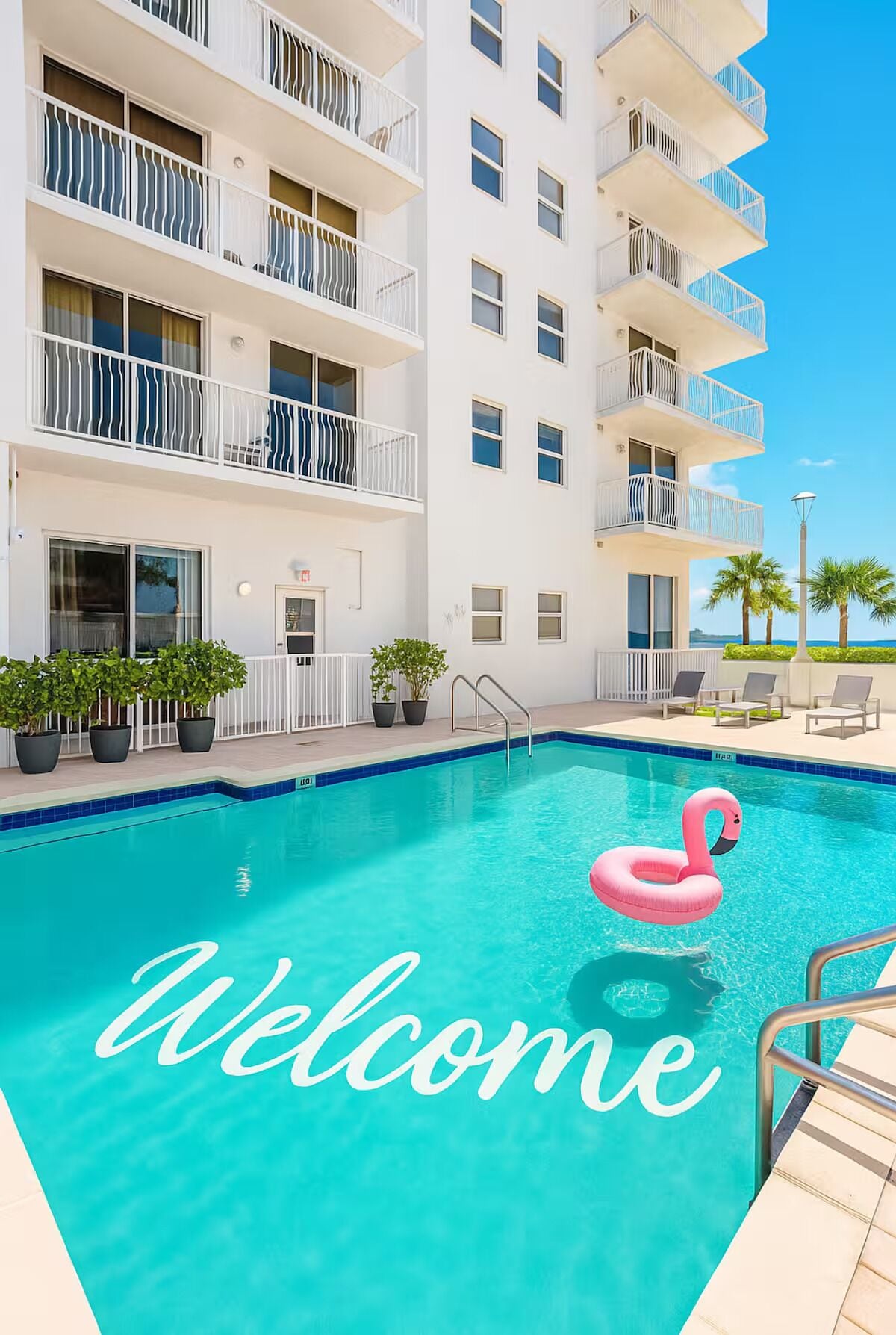 Un hôtel moderne doté d’une piscine et d’un grand flotteur en forme de flamant rose.