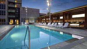 A swimming pool with lounge chairs and a bar area, surrounded by modern buildings. - Skyline Penthouse - CN Tower Downtown (Toronto)