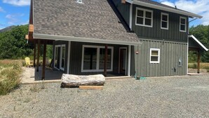 Une maison à deux étages, dotée d’un toit en pente, d’une cheminée et d’un porche abrité.