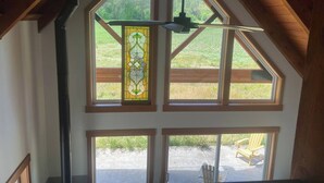 Une pièce dotée d’un plafond en pente, de grandes fenêtres et d’un vitrail décoratif.