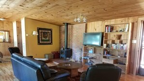 A cozy living room with a fireplace, leather sofa, and a bookshelf. - Ruch Refuge in Jacksonville (Jacksonville)