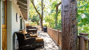 An outdoor patio with wicker furniture, a table, and a grill. - Jacksonville Creekside Inn (Jacksonville)