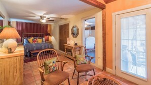 A bedroom with a bed, two chairs, a desk, and a ceiling fan. - Chile Roja Downright Comfort, Mexico Style (Comfort)