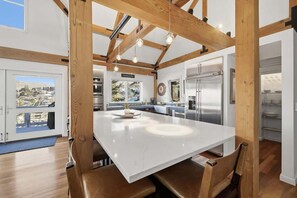 A modern kitchen with a large island, wooden beams, and stainless steel appliances. - Old Town Park City House Walk to Main Street (Park City)