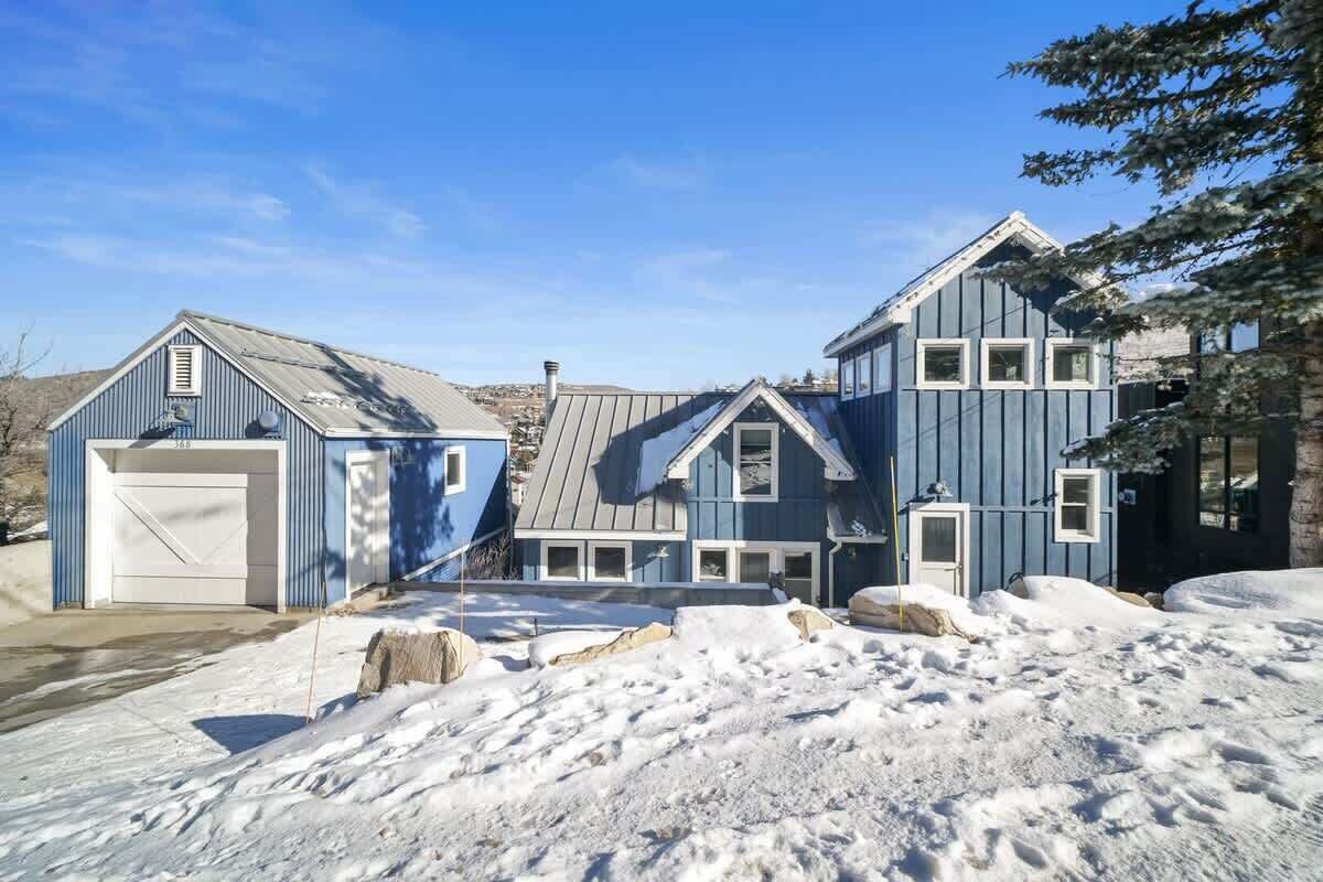 Ein Wohnhaus mit Garage, überdachter Veranda und verschneitem Einfahrt.