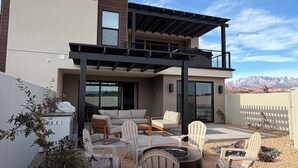 A modern two-story house with a patio area featuring outdoor furniture and a fire pit. - Sol Haven Washington, Utah (Washington)