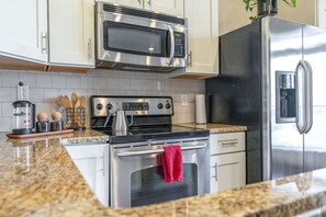 A modern kitchen with stainless steel appliances, including a microwave, oven, and refrigerator. - Corner King - King Size Beds, Close to Vandy & Broadway, (Nashville)