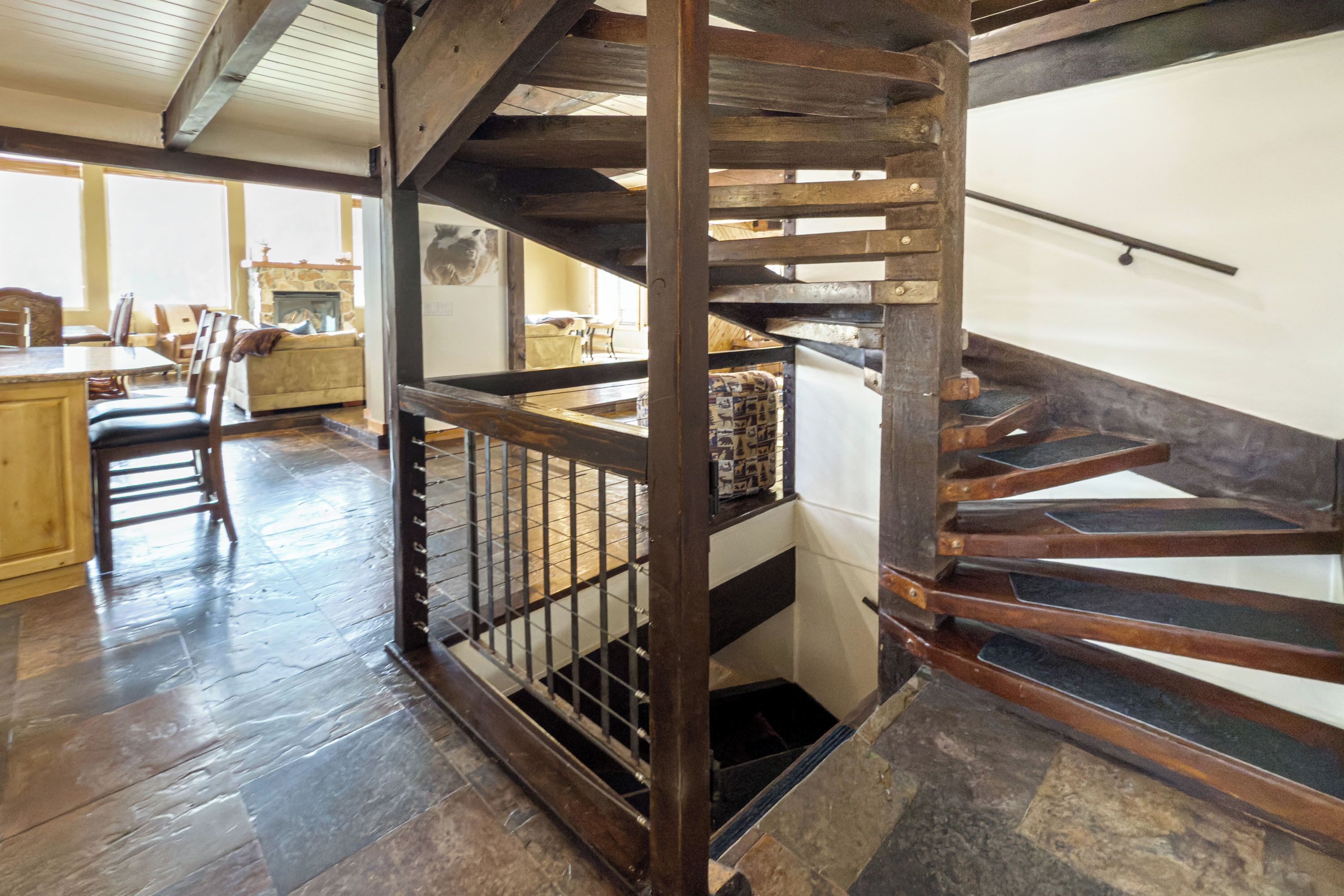 A wooden staircase with a metal railing leading to a second floor.