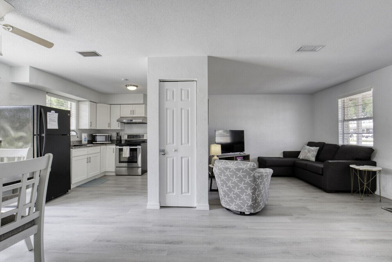 A modern apartment with a kitchen, dining area, and living room.