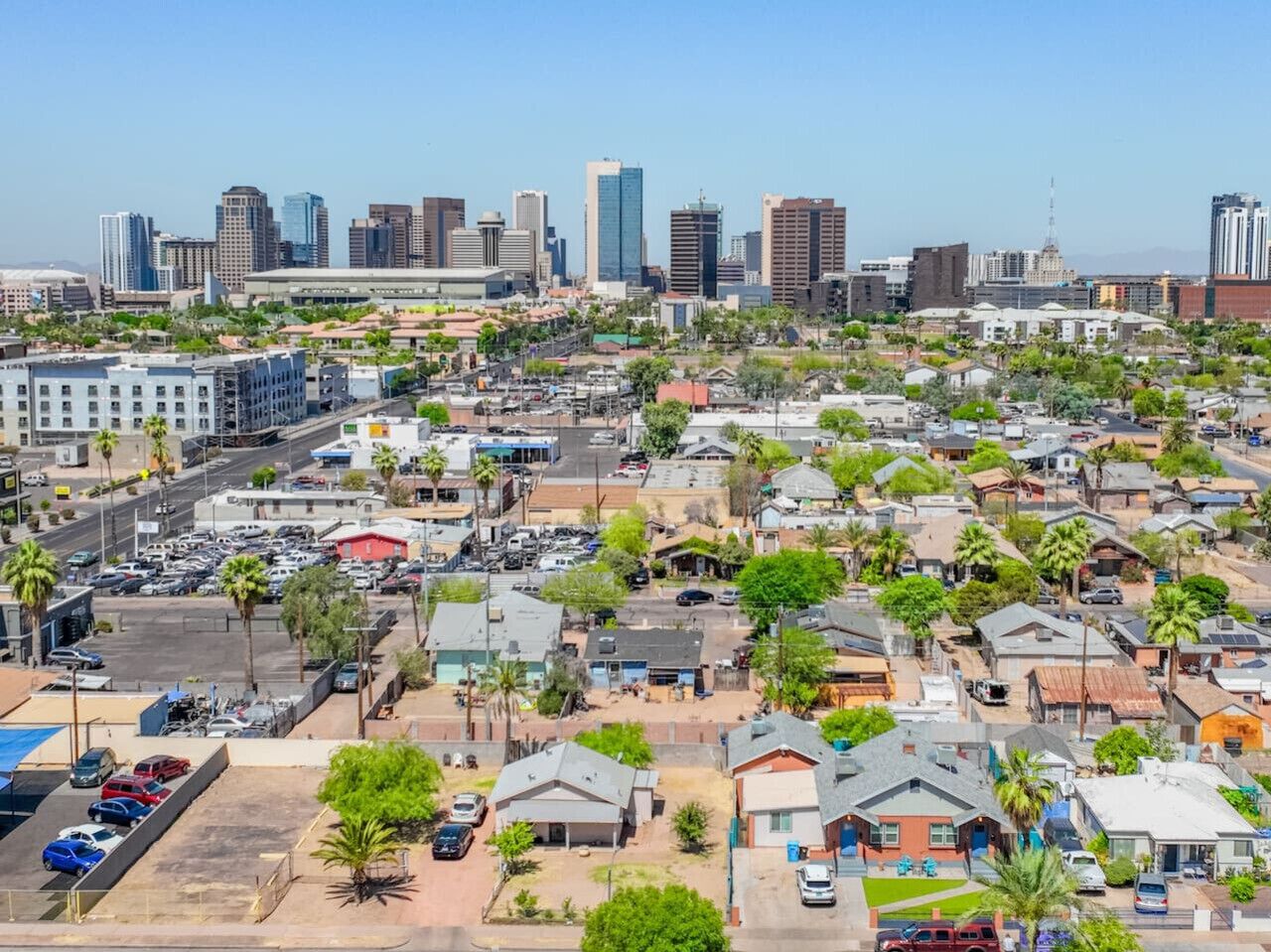 Un paisaje urbano con una mezcla de edificios residenciales y comerciales, incluyendo un rascacielos destacado al fondo.