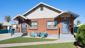 A two-story house with a blue door and windows, a small front yard with artificial grass, and a blue mailbox. - Cute & Cozy Renovated APT in the Heart of Phoenix (Phoenix)