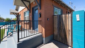 A building with a brick facade, a blue door, and a gated entrance. - Cute & Cozy Renovated APT in the Heart of Phoenix (Phoenix)