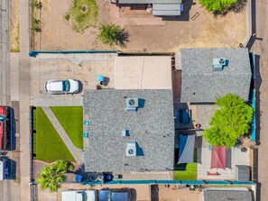 Vista aérea de una zona residencial con varias casas, un estacionamiento y un césped verde.