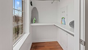A small, bright room with a wooden floor, a window, a radiator, and a shelf with cleaning supplies. - Cozy and Comfortable 1-br in the Heart of Detroit (Detroit)