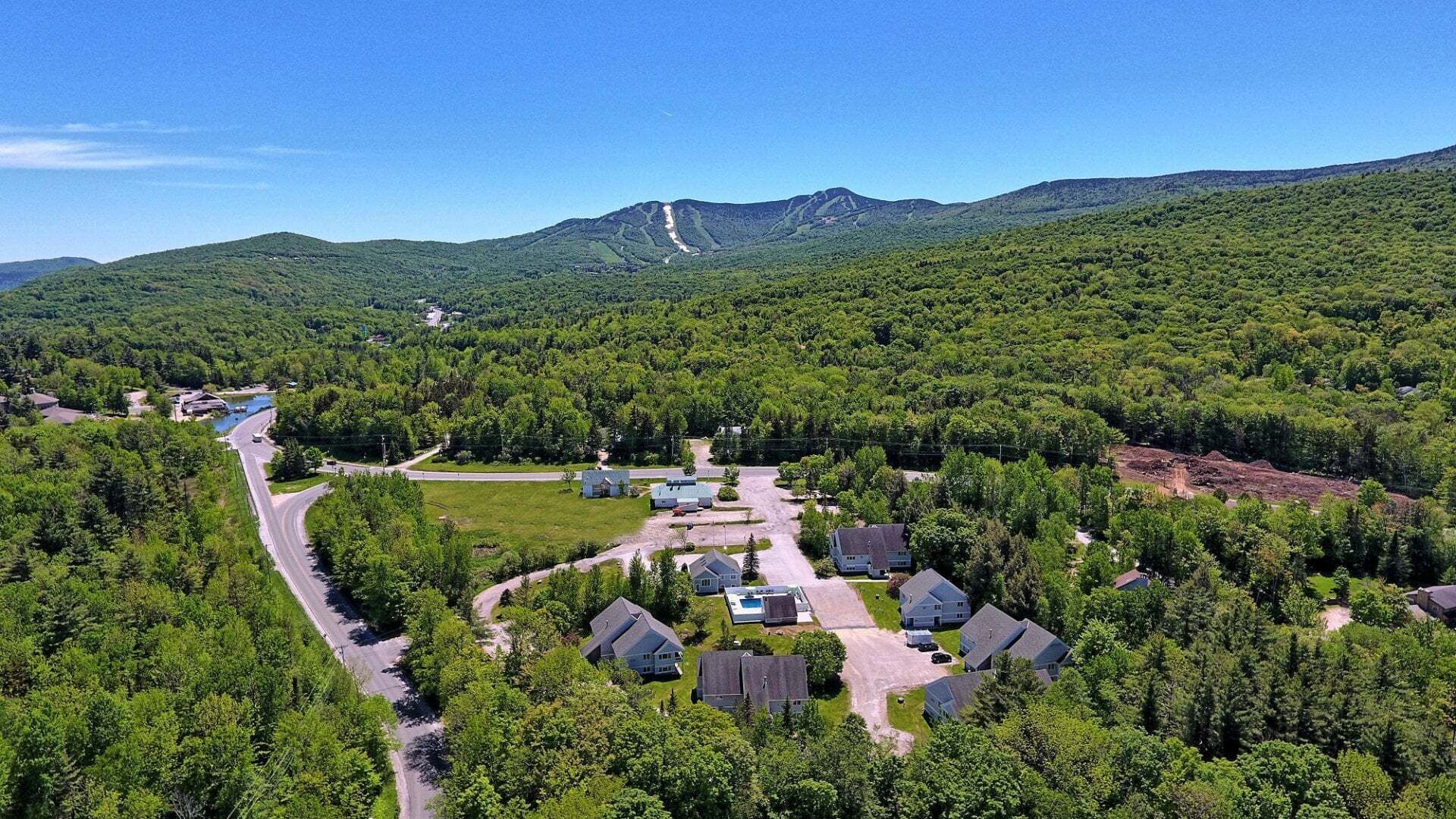 A residential area with houses, roads, and a mountain in the background.