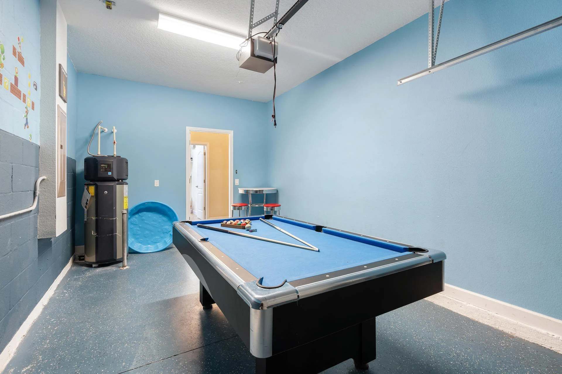 A pool table in a room with blue walls and a door.