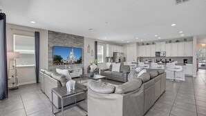 Ein modernes Wohnzimmer mit einer Eckcouch, einem Couchtisch und einem Flachbildfernseher.
