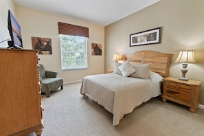 A bedroom with a bed, a nightstand, a lamp, a dresser, and a television. - Cp8107-305 Windsor Palms Resort Vacation Condo (Kissimmee)