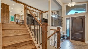 Eine Holztreppe mit Metallgeländer, die zu einer zweiten Etage führt.