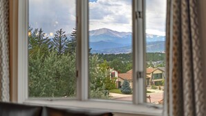 Ein Fenster mit Blick auf ein Gebirge und eine Wohngegend.