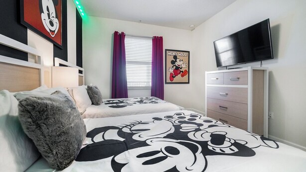 A bedroom with a bed, a dresser, a television, and a Mickey Mouse poster. - Ctd4751-401 (Kissimmee)