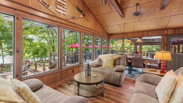 A spacious room with large windows, wooden ceiling, and comfortable seating. - Cool Goose Landing Private Dock Large Deck Game Room 61 (Cadiz)