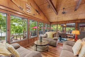 A spacious room with large windows, wooden ceiling, and comfortable seating. - Cool Goose Landing Private Dock Large Deck Game Room 61 (Cadiz)
